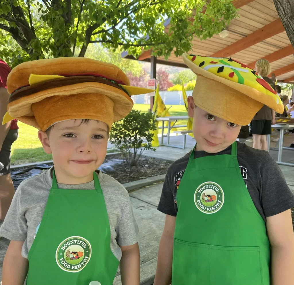 Two boys with funny food hats and aprons